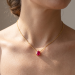 Load image into Gallery viewer, Ruby-red teardrop pendant necklace worn at the collarbone in natural daylight — 18K gold plated 925 sterling silver
