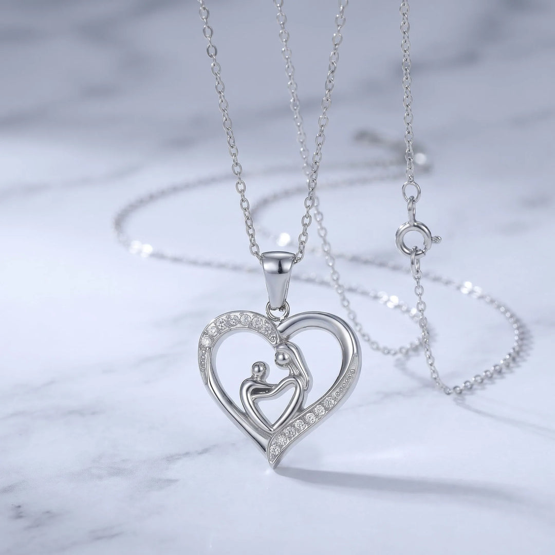 Mom Heart Necklace in silver-tone stainless steel styled on a marble surface