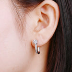 Load image into Gallery viewer, Woman wearing sparkling moissanite hoop earrings in silver

