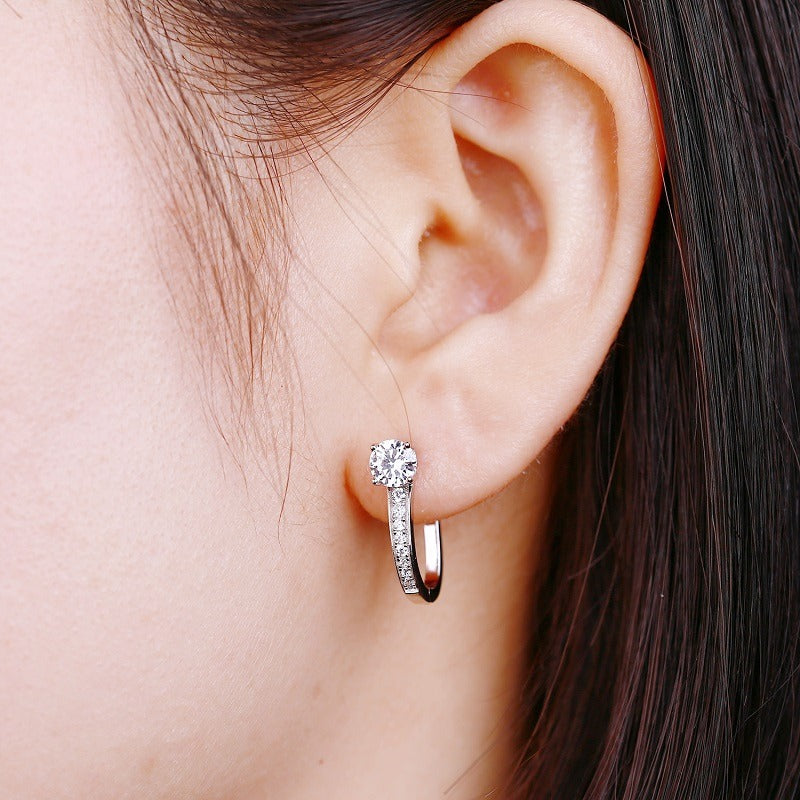 Woman wearing sparkling moissanite hoop earrings in silver