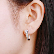 Woman wearing sparkling moissanite hoop earrings in silver